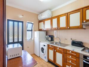 een keuken met een wastafel, een wasmachine en een droger bij Apartment Quinta do Torrejão by Interhome in Porches +16 foto's