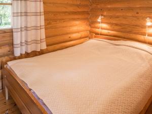 a bed in a wooden room with a window at Holiday Home Ruka-kitkan käki by Interhome in Säkkilänvaara