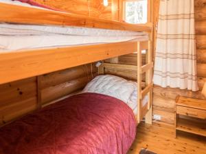 a bedroom with two bunk beds in a log cabin at Holiday Home Ruka-kitkan käki by Interhome in Säkkilänvaara