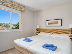 a bedroom with a large white bed with blue towels on it at Apartment Calahonda Royale by Interhome in Sitio de Calahonda