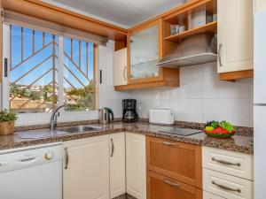 a kitchen with white cabinets and a sink and a window at Apartment Calahonda Royale by Interhome in Sitio de Calahonda
