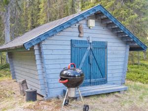 ein blauer Schuppen mit einem Grill davor in der Unterkunft Holiday Home Pöllölaakso by Interhome in Ruka