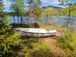 ein Boot im Gras neben einem See in der Unterkunft Holiday Home Pöllölaakso by Interhome in Ruka