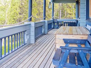 eine Holzterrasse mit einem Holztisch und Bänken in der Unterkunft Holiday Home Pöllölaakso by Interhome in Ruka + 24 Fotos