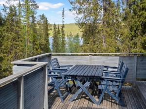 eine Holzterrasse mit einem Picknicktisch und Stühlen darauf in der Unterkunft Holiday Home Pöllölaakso by Interhome in Ruka