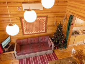a living room with a couch and a christmas tree at Holiday Home Joulupukin mökki by Interhome in Sonka