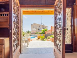 una puerta abierta a un patio trasero con piscina en Holiday Home Lleida by Interhome, en Torredembarra