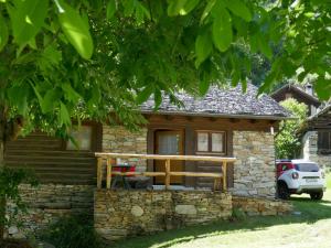 uma pequena casa de pedra com um alpendre de madeira em Holiday Home Rustico Ingrid - MVA338 by Interhome em Semione