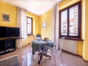 a dining room with a table and chairs and a tv at Apartment Squisleep-1 by Interhome in San Daniele del Friuli