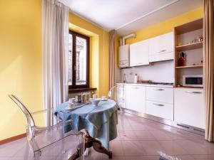 una cocina con una mesa pequeña y una cocina con paredes amarillas. en Apartment Squisleep-1 by Interhome, en San Daniele del Friuli