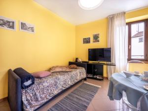 1 dormitorio con cama, mesa y TV en Apartment Squisleep-1 by Interhome, en San Daniele del Friuli