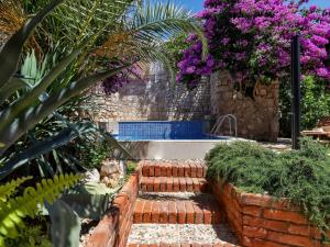 a garden with brick steps and purple flowers at Holiday Home Marijan by Interhome in Sutivan