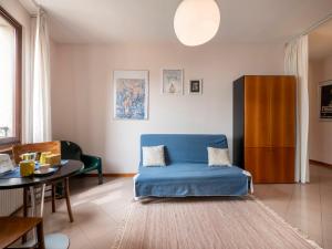 a living room with a blue couch and a table at Apartment Squisleep-2 by Interhome in San Daniele del Friuli