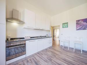 kuchnia z białymi szafkami i drewnianą podłogą w obiekcie Holiday Home Elena by Interhome w mieście Altopascio +16 zdjęć