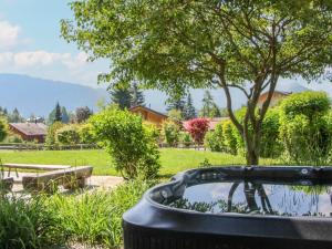 a hot tub in a garden with a tree at Chalet Les 3 Soeurs by Interhome in Villars-sur-Ollon