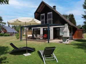 FrielendorfにあるHoliday Home Ferienwohnpark Silbersee by Interhomeの草の中に椅子と傘