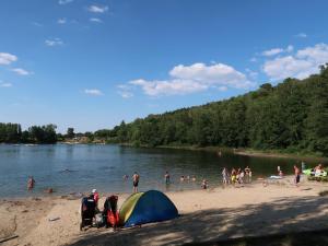a group of people on a beach with a tent at Holiday Home Ferienwohnpark Silbersee by Interhome in Frielendorf