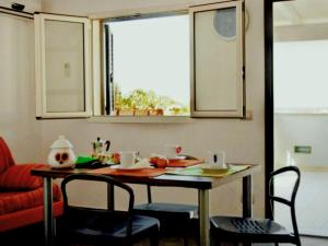 un tavolo e sedie in un soggiorno con finestre di Apartment Cava Larica by Interhome a Cava dʼAliga