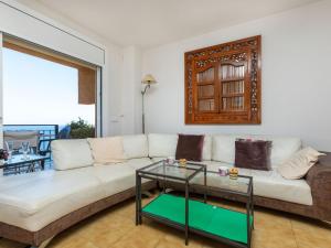 a living room with a white couch and a glass table at Apartment S'Adolitx by Interhome in Sant Feliu de Guíxols