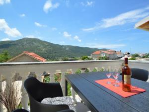 a bottle of wine sitting on a table on a balcony at Apartment Miro-1 by Interhome in Grebaštica