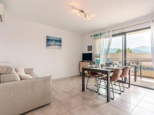 Una sala de estar con una mesa y sillas y un sofá. en Apartment Le Clos des Alberes-1 by Interhome, en Argelès-sur-Mer