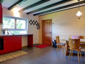 a kitchen and dining room with a table and chairs at Holiday Home Chalet Ninette by Interhome in Eischoll