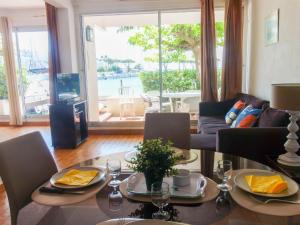 a living room with a table and chairs and a couch at Apartment Le Nirvana-2 by Interhome in Le Grau-du-Roi