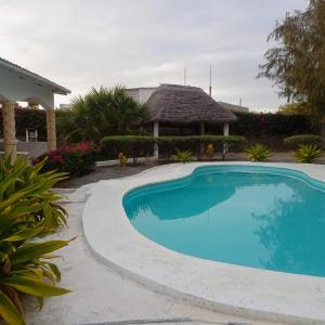 a swimming pool in front of a house at 2 Bedroom Mangrove Cottage with Private Pool in Watamu