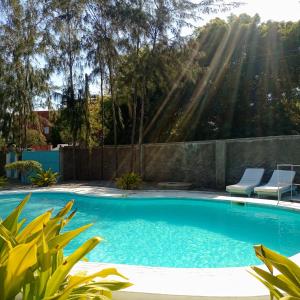 2 Bedroom Mangrove Cottage with Private Pool في واتامو: مسبح مع كرسيين في حديقه خلفيه