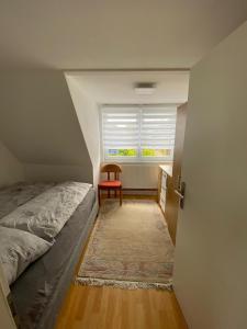 um quarto com uma cama e uma janela com uma cadeira em Strandnähe em Scharbeutz