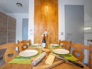 een houten tafel met een fles wijn en kaas bij Apartment Altineige 104 by Interhome in Val Thorens +23 foto's