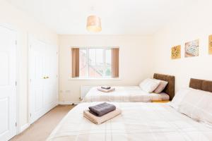 a white room with two beds and a couch at Great 4 bed house in Black Country in Tipton