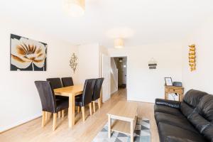 a living room with a table and chairs and a couch at Great 4 bed house in Black Country in Tipton