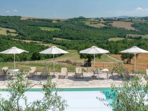 a pool with umbrellas and chairs and a view of a hill at Villa Futura by Interhome in Lorgnano