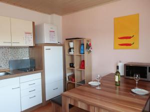 eine Küche mit einem Tisch und einem weißen Kühlschrank in der Unterkunft Apartment Leon by Interhome in Nentershausen