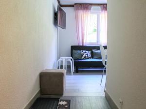 uma sala de estar com um sofá e uma cadeira em Apartment Grenat 8 by Interhome em Villars-sur-Ollon