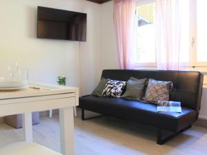 a living room with a black couch and a table at Apartment Grenat 8 by Interhome in Villars-sur-Ollon +24 photos