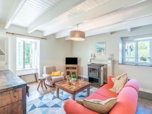 a living room with a red couch and a table at Holiday Home Ti ar Stang by Interhome in Esquibien