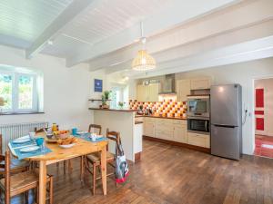 a kitchen with a table and a refrigerator at Holiday Home Ti ar Stang by Interhome in Esquibien