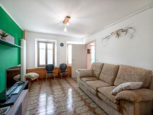 a living room with a couch and a tv at Holiday Home La Predaia by Interhome in Barcis