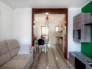 a living room with a couch and a kitchen at Holiday Home La Predaia by Interhome in Barcis