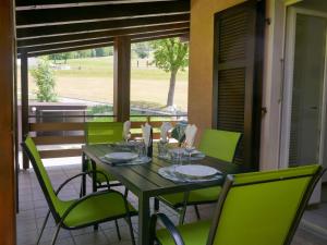 a table with green chairs on a porch with a view at Holiday Home Terry by Interhome in Olivone