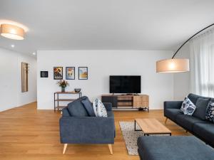 een woonkamer met twee banken en een tv bij Apartment LocTowers A4-8-2 by Interhome in Locarno
