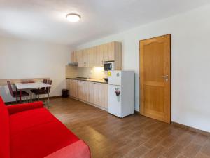 a living room with a red couch and a kitchen at Holiday Home Bzí by Interhome in Dolní Bukovsko +35 photos