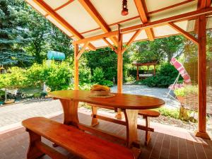 a wooden table and a bench on a patio at Holiday Home Jazmin by Interhome in Balatonszárszó