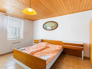 a bedroom with a bed and a clock on the wall at Holiday Home Bzí by Interhome in Dolní Bukovsko