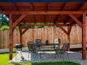 patio z grillem i krzesłami pod drewnianą pergolą w obiekcie Holiday Home Dehtáře by Interhome w mieście Hluboká nad Vltavou
