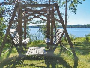 two chairs sitting on a swing by the water at Holiday Home Leponiemi by Interhome in Saarijärvi