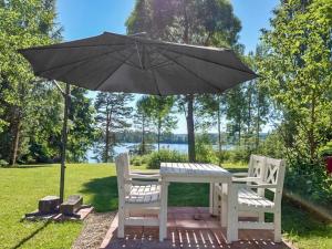 uma mesa e duas cadeiras debaixo de um guarda-sol em Holiday Home Leponiemi by Interhome em Saarijärvi