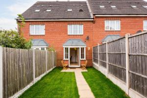 a house with a fence and a green yard at Great 4 bed house in Black Country in Tipton